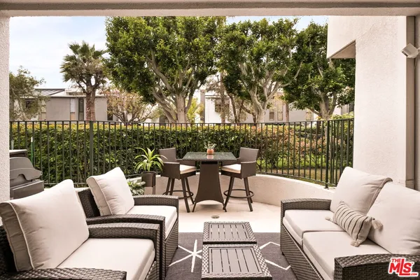 a view of a patio with couches table and chairs and potted plants