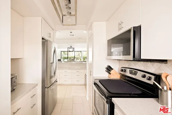 a kitchen with stainless steel appliances granite countertop a refrigerator and a stove