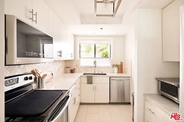 a kitchen that has a sink and a stove in it