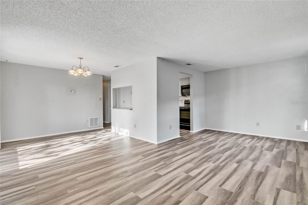 4907 Lake Ridge Road, Unit H Orlando, FL 32808 - Photo 2 of 14 wooden floor in an empty room with a kitchen