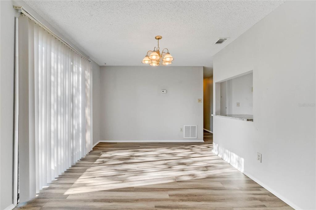 4907 Lake Ridge Road, Unit H Orlando, FL 32808 - Photo 4 of 14 a view of an empty room with wooden floor and a window