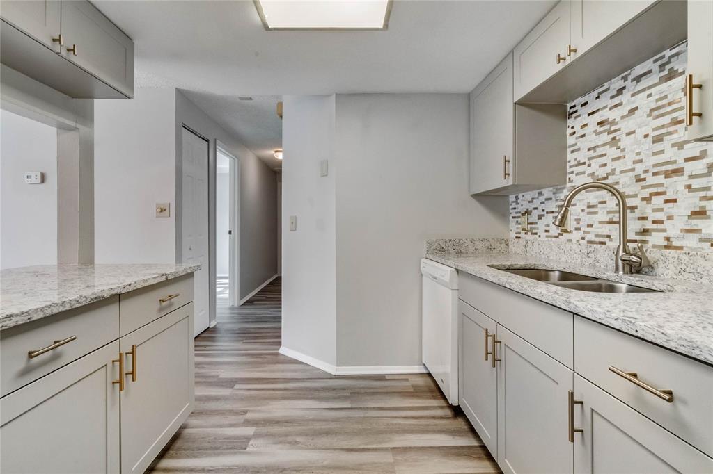 4907 Lake Ridge Road, Unit H Orlando, FL 32808 - Photo 7 of 14 a bathroom with a granite countertop sink and a mirror