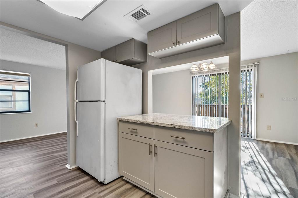 4907 Lake Ridge Road, Unit H Orlando, FL 32808 - Photo 8 of 14 a kitchen with granite countertop a refrigerator and a sink
