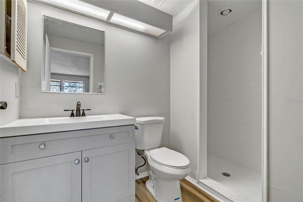 4907 Lake Ridge Road, Unit H Orlando, FL 32808 - Photo 10 of 14 a bathroom with a sink a toilet and shower
