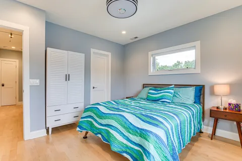 a bedroom with a bed and a painting on the wall