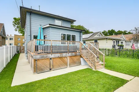 a view of a house with a yard and deck