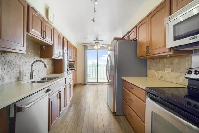 a kitchen with stainless steel appliances granite countertop a sink stove and refrigerator