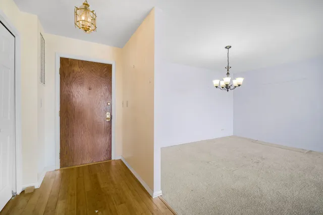 a view of empty room with a chandelier fan and wooden floor