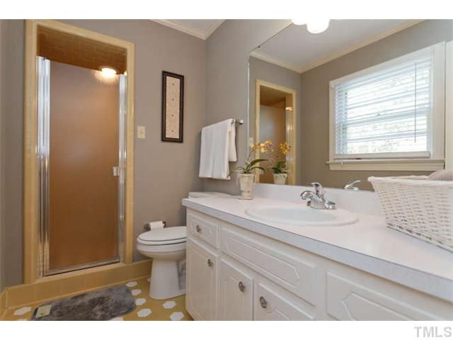 1605 Su John Road Raleigh, NC 27607 - Photo 10 of 25 a bathroom with a sink a toilet a mirror and shower