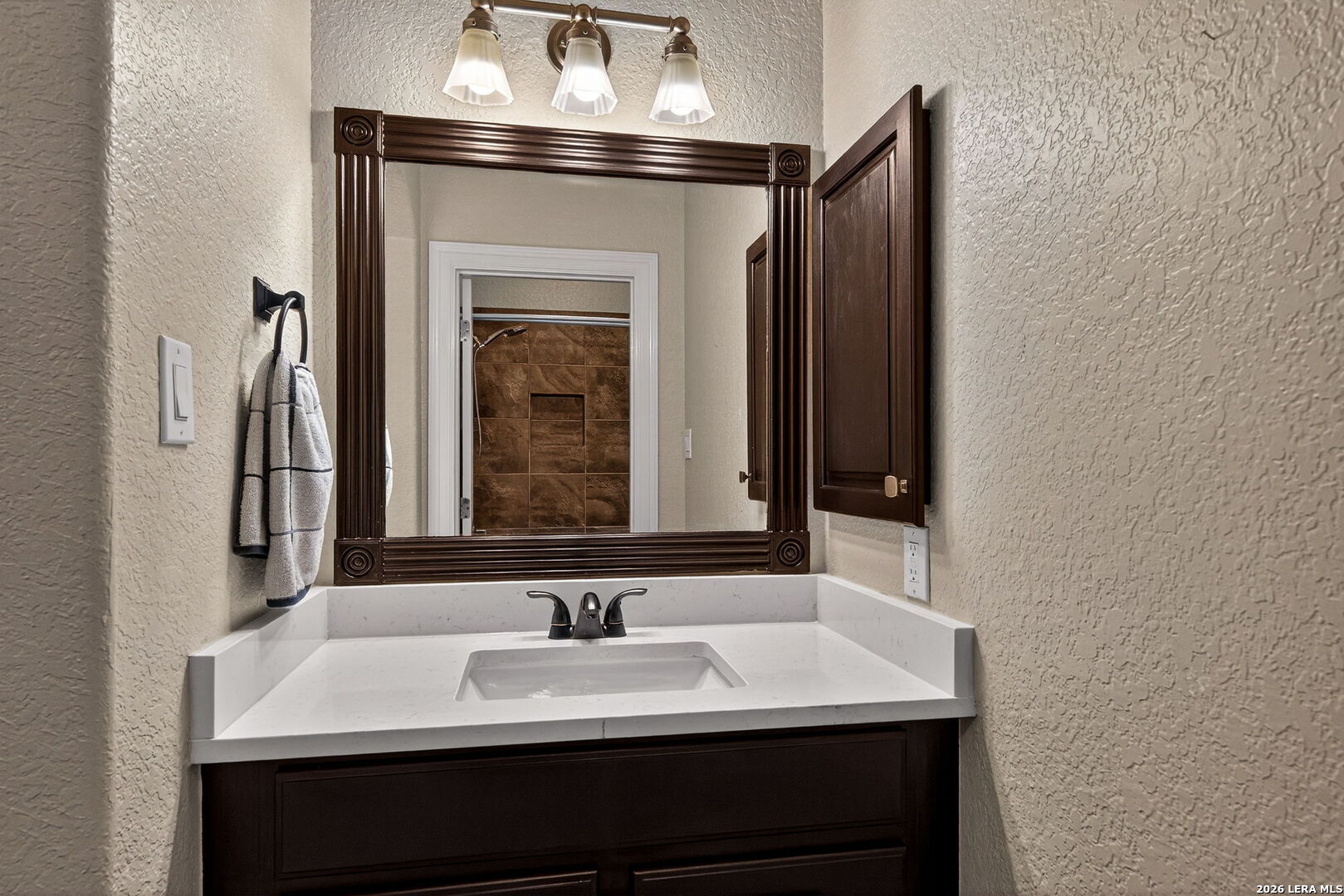 24511 Bogey Ridge San Antonio, TX 78258 - Photo 22 of 39 a en suite bathroom with a sink and a mirror