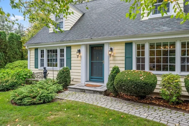 a view of a big house with a big yard and large trees