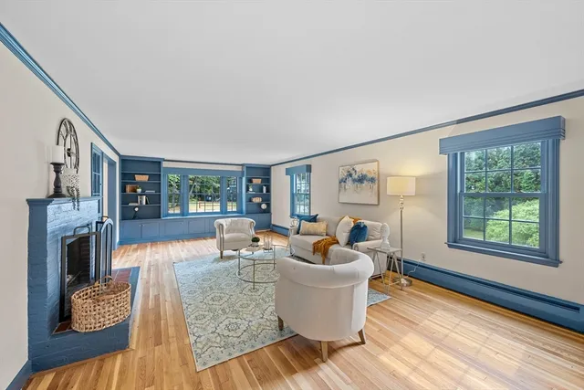 a living room with furniture a fireplace and a large window