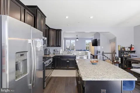 a kitchen with stainless steel appliances granite countertop a refrigerator stove microwave and sink