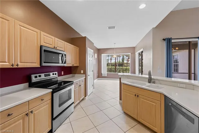 a kitchen with granite countertop a stove sink and microwave