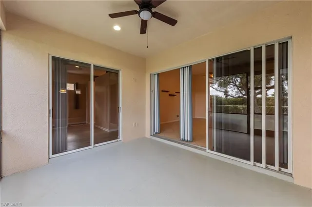 a view of a hallway with wooden floor and a ceiling fan