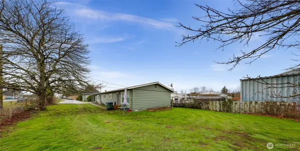 a backyard of a house with wooden fence and large trees