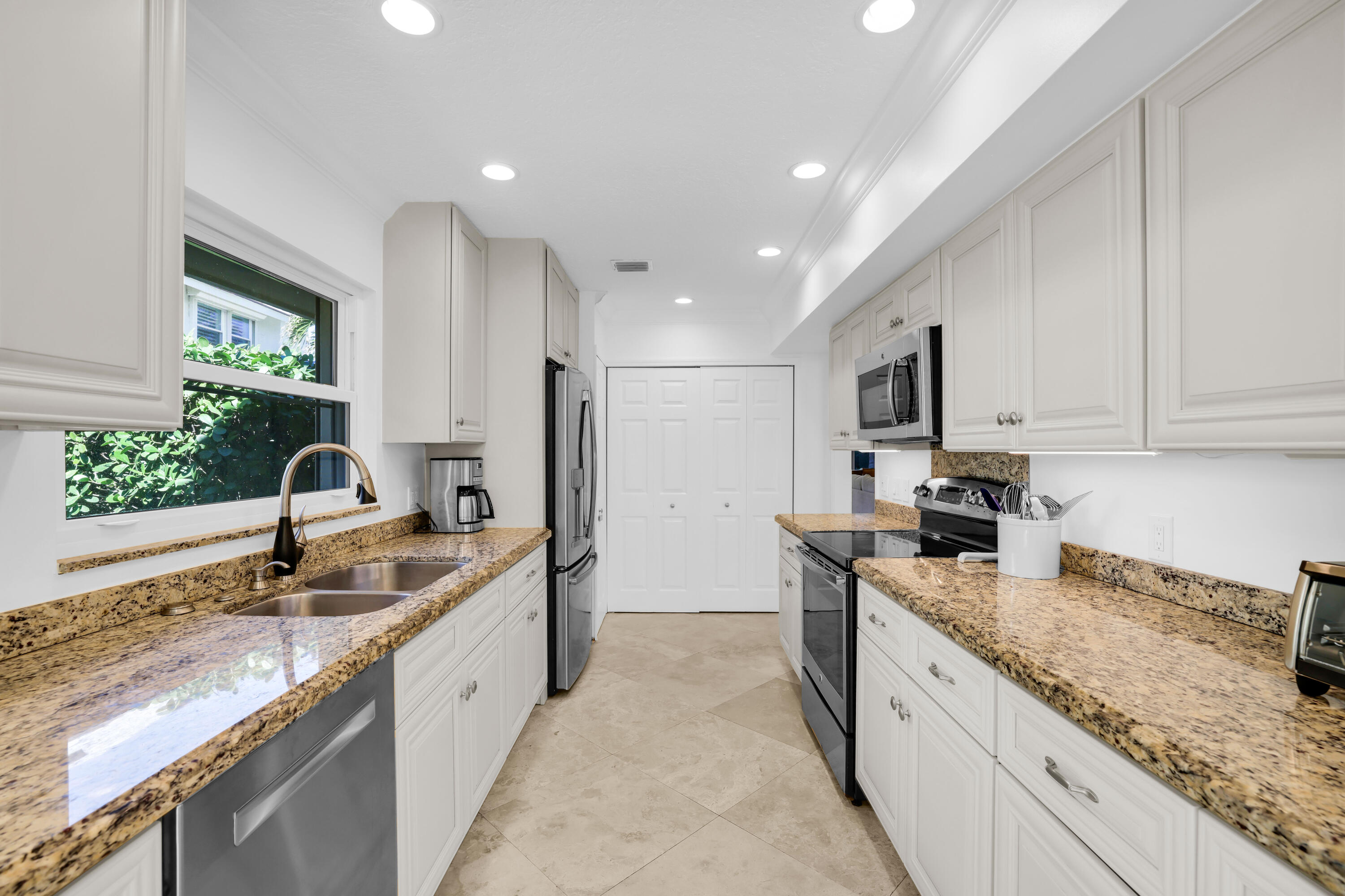 4161 U.S. Highway 1, Unit I2 Jupiter, FL 33477 - Photo 11 of 64 a kitchen with granite countertop stainless steel appliances a sink a stove and a counter top space