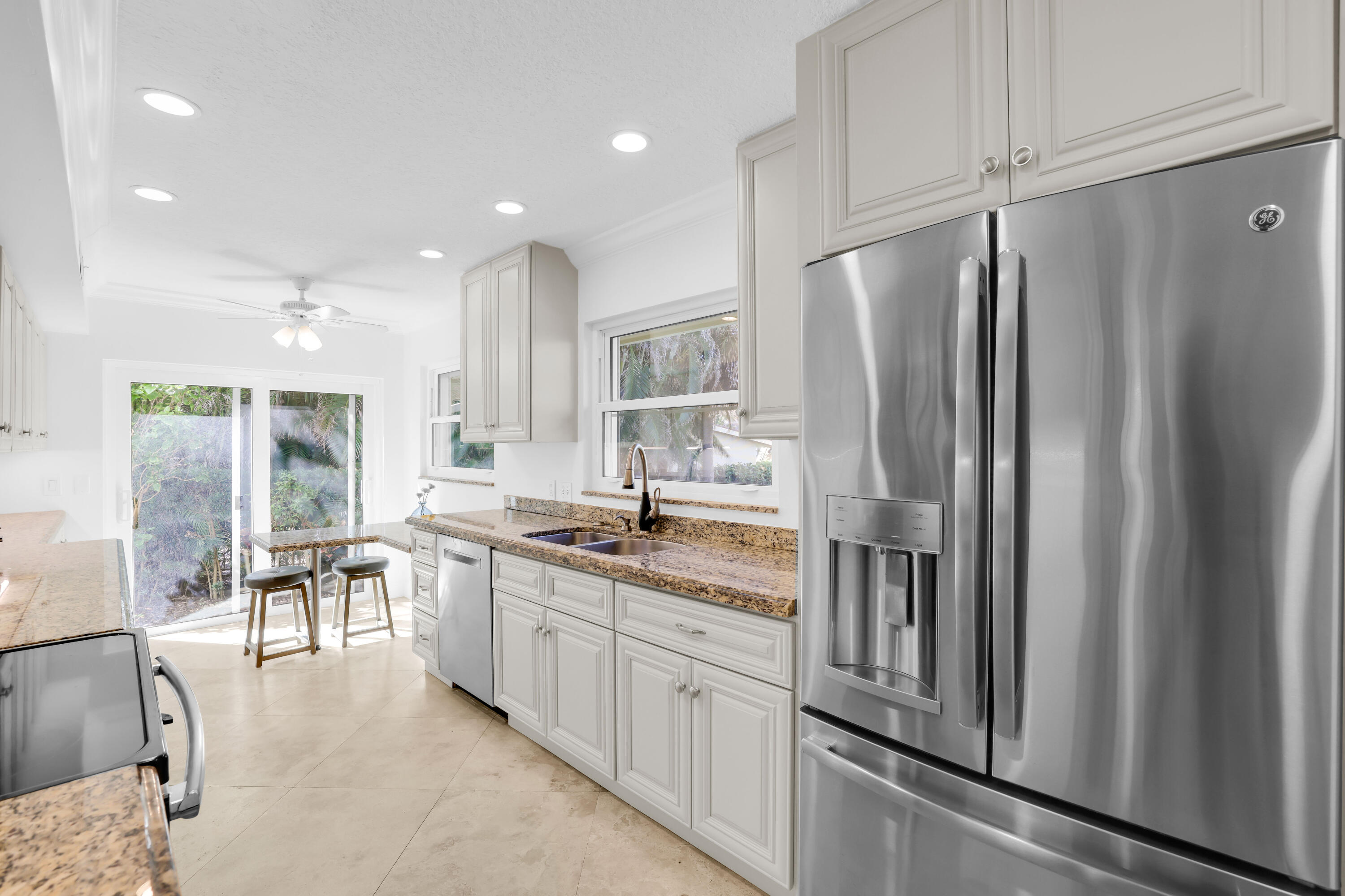 4161 U.S. Highway 1, Unit I2 Jupiter, FL 33477 - Photo 12 of 64 a kitchen with stainless steel appliances granite countertop a refrigerator and a stove top oven