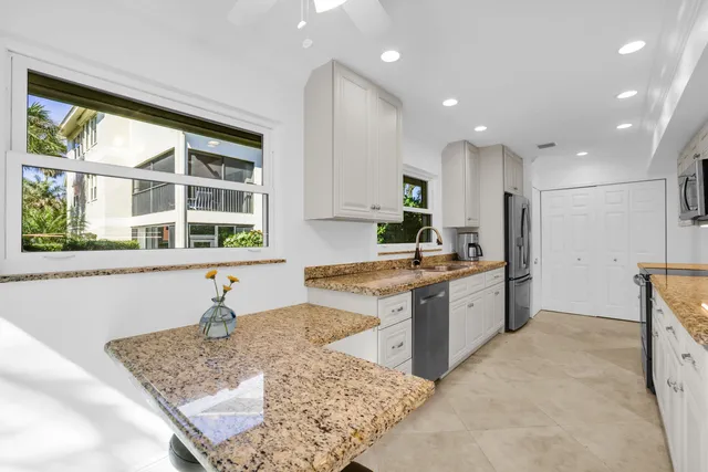 a kitchen with granite countertop a sink and a window