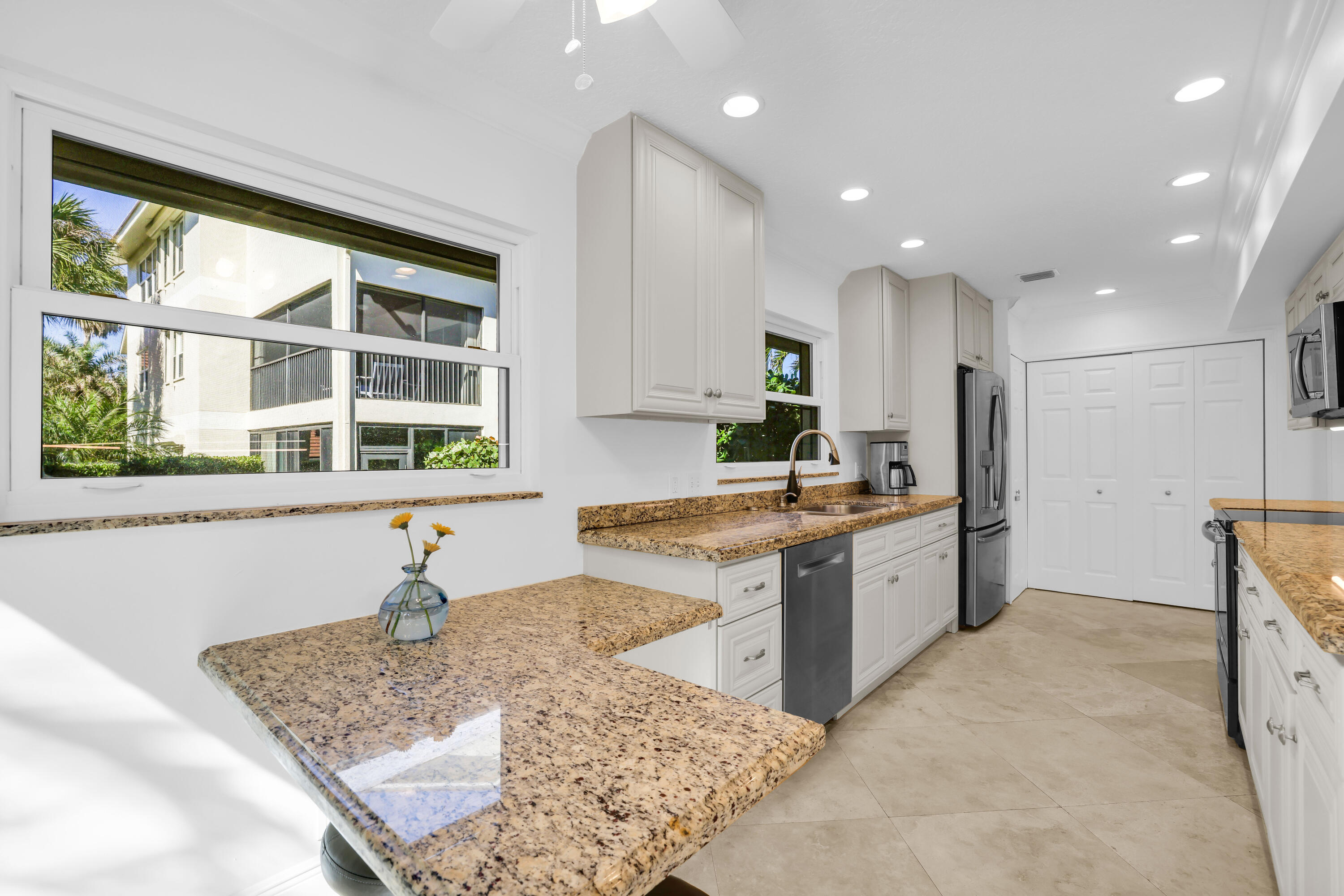 4161 U.S. Highway 1, Unit I2 Jupiter, FL 33477 - Photo 15 of 64 a kitchen with a sink stove and cabinets