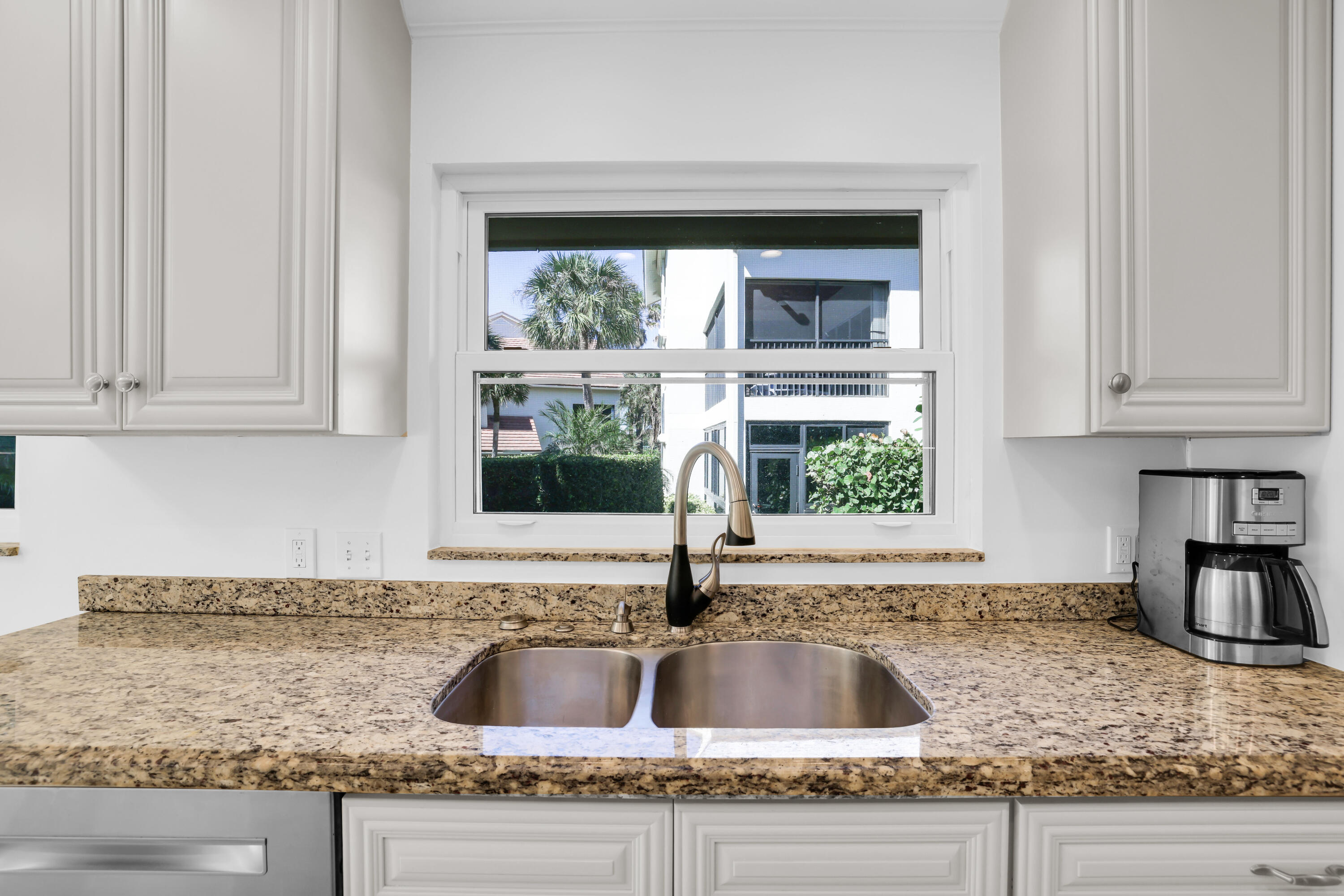 4161 U.S. Highway 1, Unit I2 Jupiter, FL 33477 - Photo 16 of 64 a kitchen with granite countertop a sink and a window