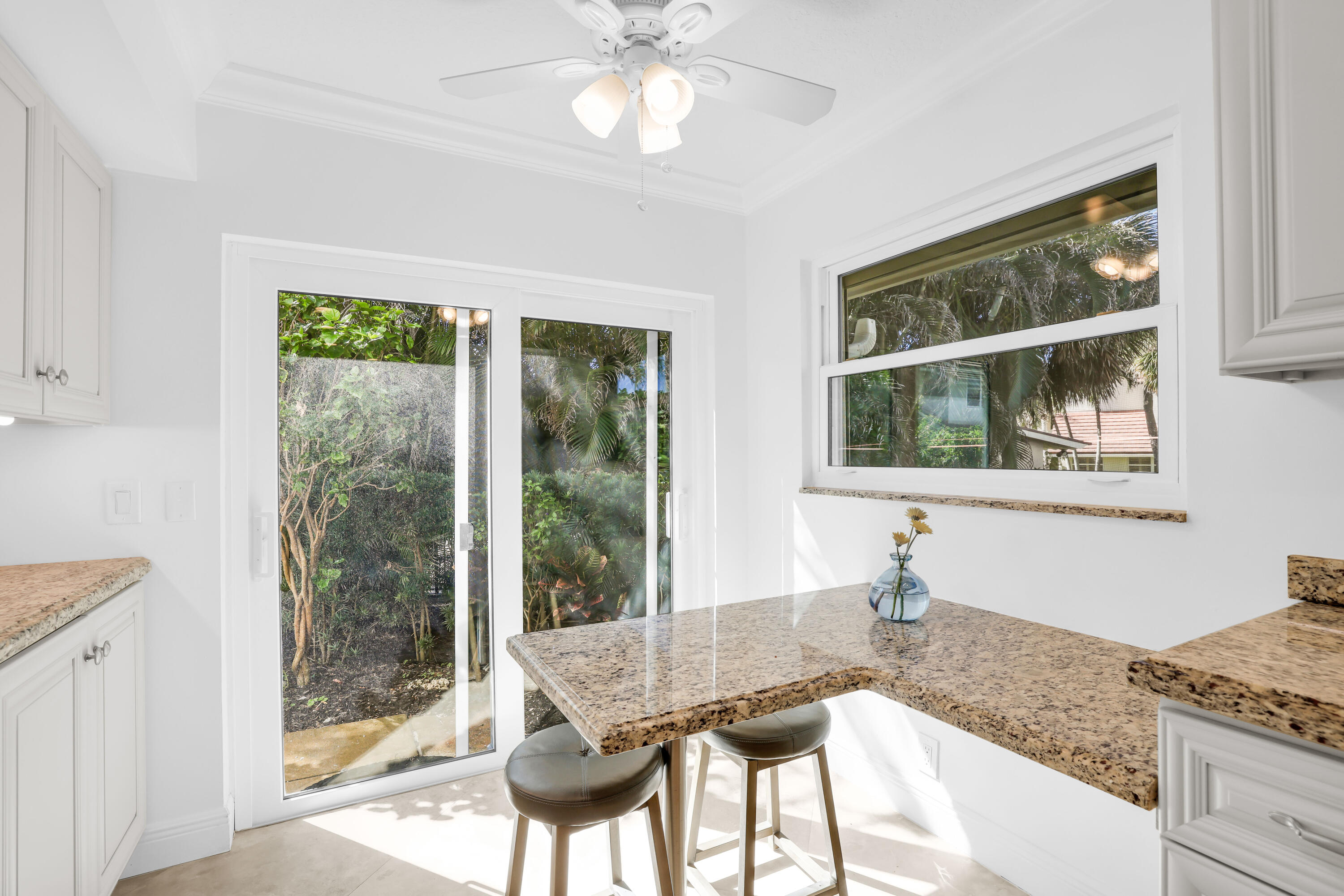 4161 U.S. Highway 1, Unit I2 Jupiter, FL 33477 - Photo 19 of 64 a dining room with wooden floor and a floor to ceiling window
