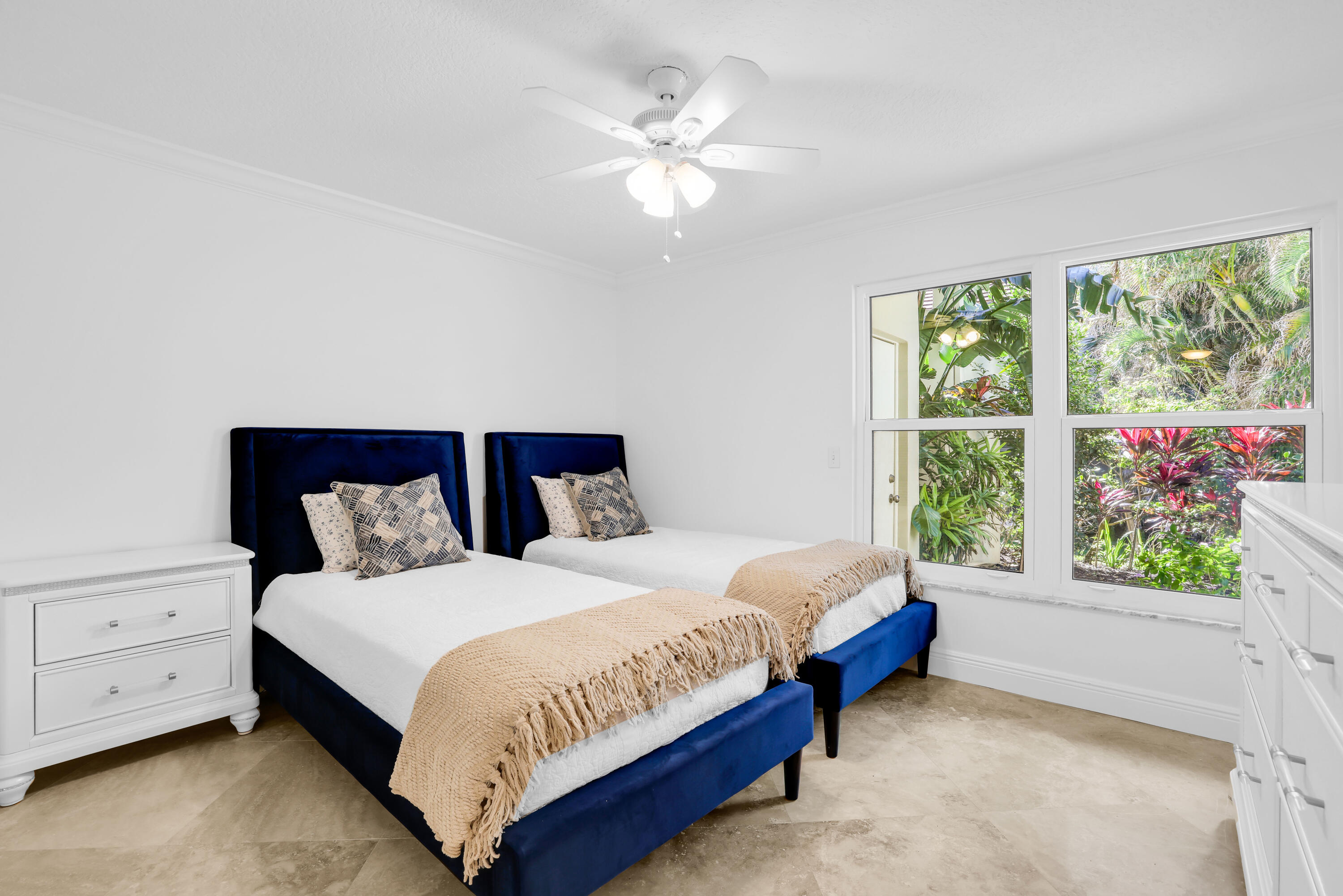 4161 U.S. Highway 1, Unit I2 Jupiter, FL 33477 - Photo 27 of 64 a bedroom with a large bed and a chandelier fan