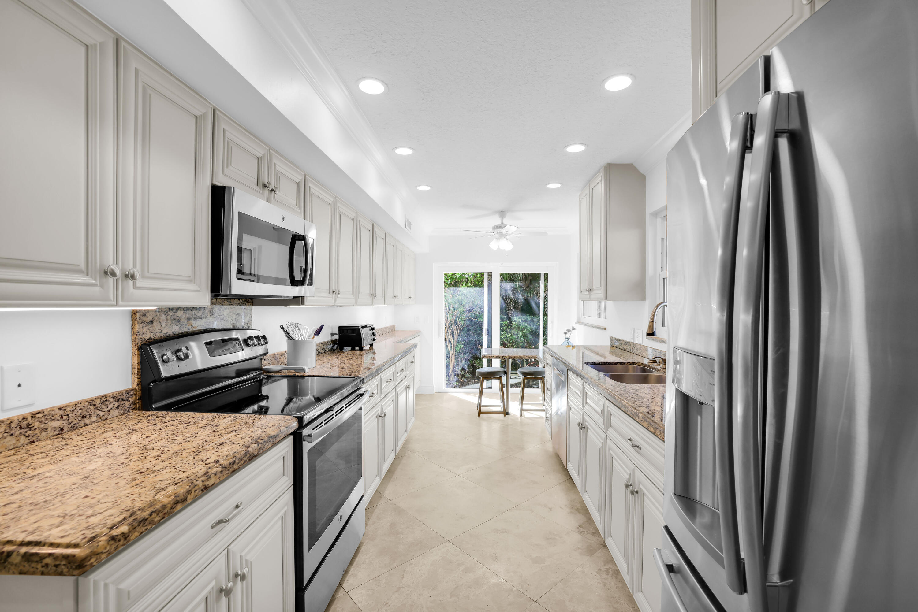 4161 U.S. Highway 1, Unit I2 Jupiter, FL 33477 - Photo 3 of 64 a kitchen with stainless steel appliances granite countertop a refrigerator a stove and a sink