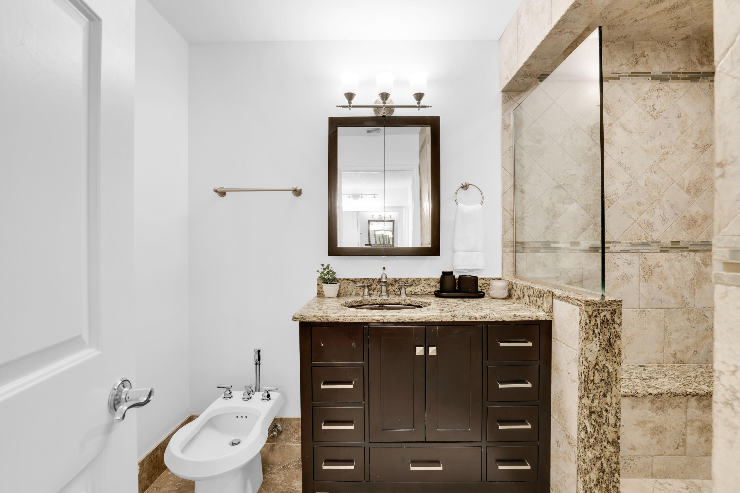 4161 U.S. Highway 1, Unit I2 Jupiter, FL 33477 - Photo 33 of 64 a bathroom with a granite countertop sink toilet and mirror