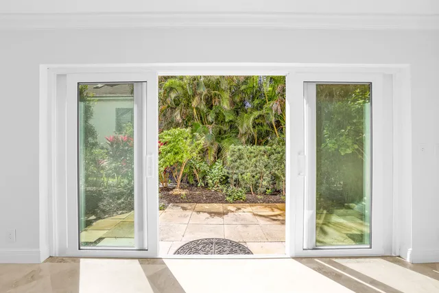 an empty room with a window and a ceiling fan
