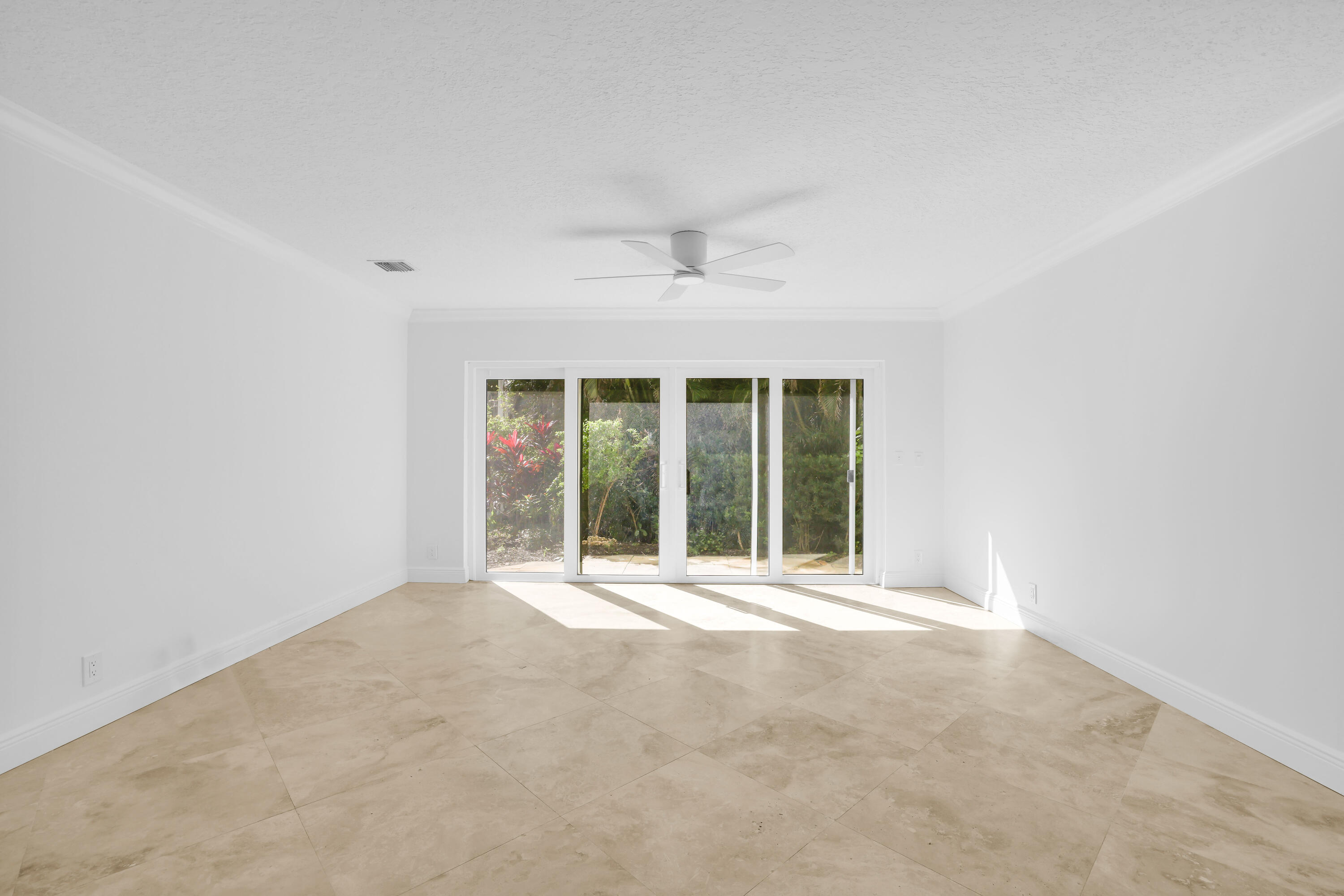 4161 U.S. Highway 1, Unit I2 Jupiter, FL 33477 - Photo 38 of 64 an empty room with a window and a ceiling fan