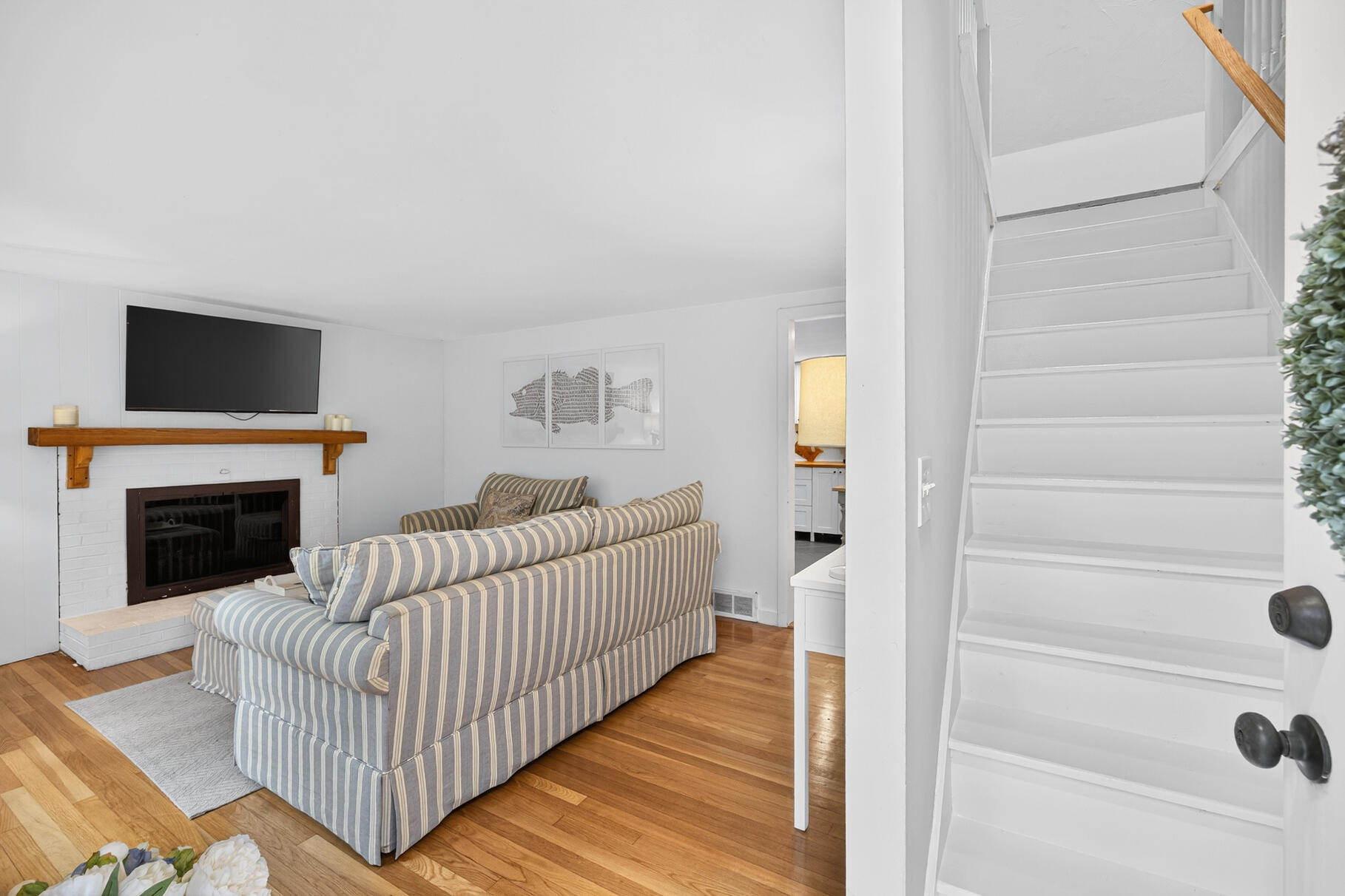 53 Main Street Sandwich, MA 02563 - Photo 2 of 33 a view of a hallway with wooden floor and a fireplace