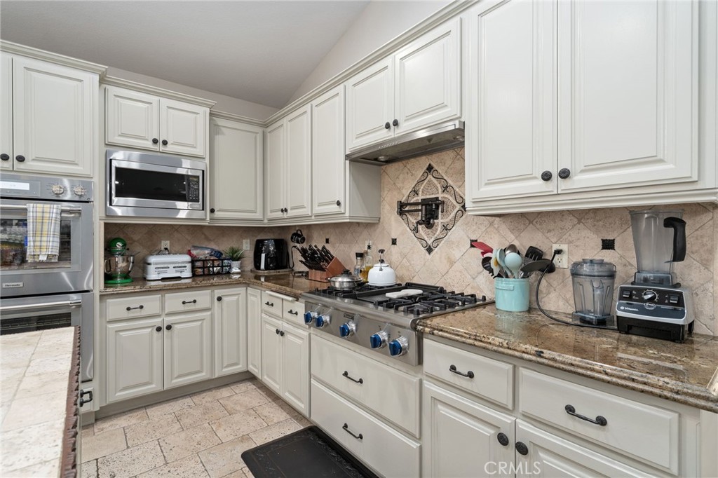 2885 Citrocado Ranch Street Corona, CA 92881 - Photo 16 of 51 a kitchen with granite countertop white cabinets and stainless steel appliances