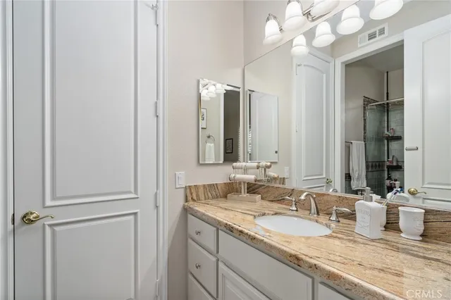 a bathroom with a granite countertop sink toilet and shower