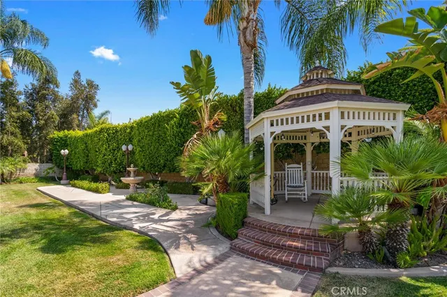 a swimming pool with outdoor seating yard and palm tree