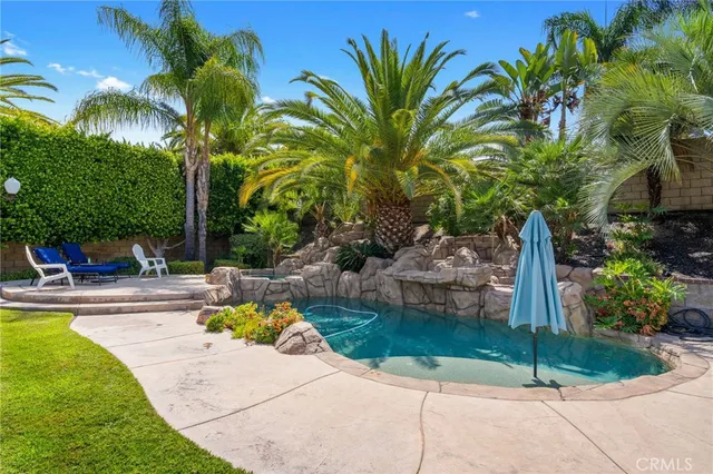 a view of a backyard with table and chairs plants and trees