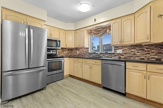 a kitchen with stainless steel appliances granite countertop a refrigerator sink and cabinets