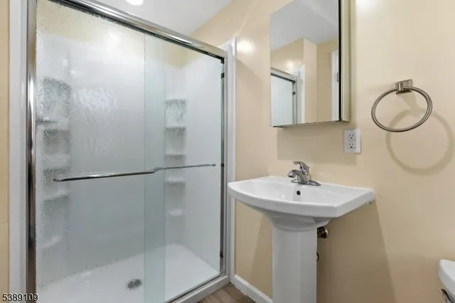a bathroom with a sink mirror and shower