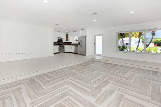 a view of kitchen with stainless steel appliances kitchen island sink and refrigerator