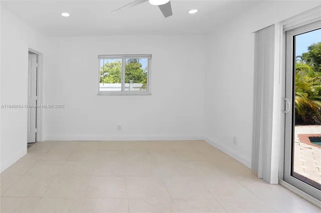 an empty room with a window and a ceiling fan