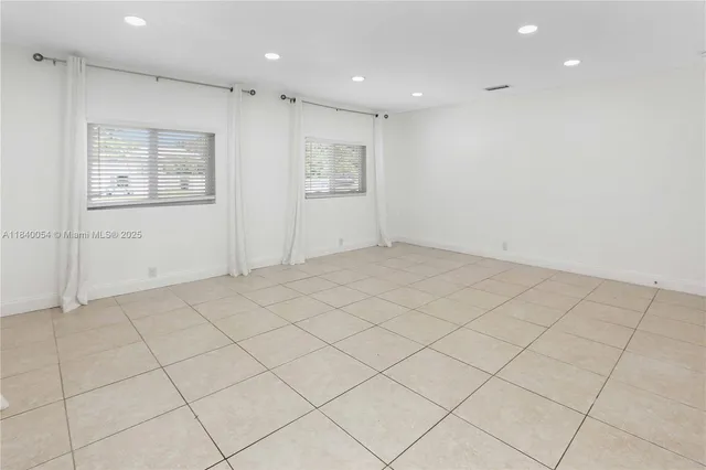 an empty room with white walls and tiles