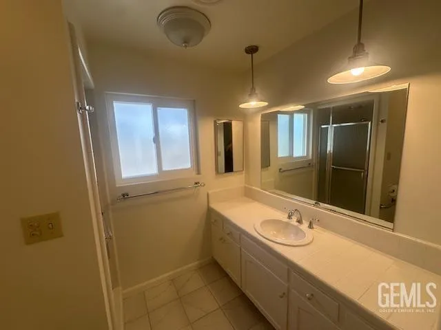 a bathroom with a sink double vanity granite and shower
