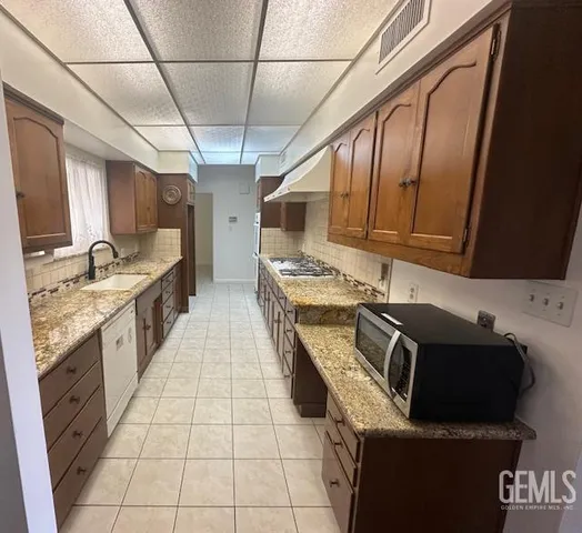 a kitchen with stainless steel appliances granite countertop a sink stove and cabinets