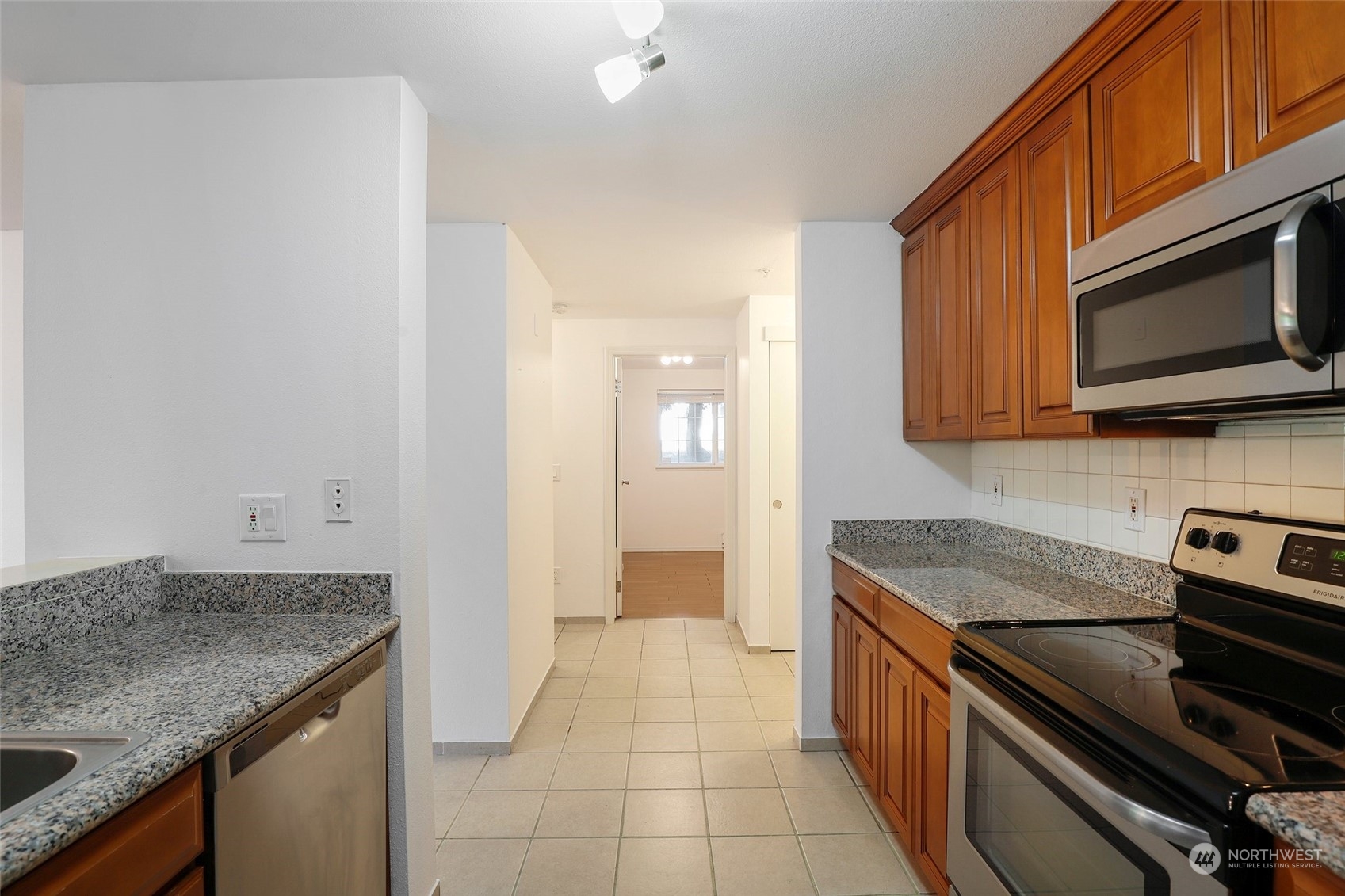 901 Sunset Boulevard Northeast, Unit D115 Renton, WA 98056 - Photo 4 of 19 a kitchen with stainless steel appliances granite countertop a sink and a stove