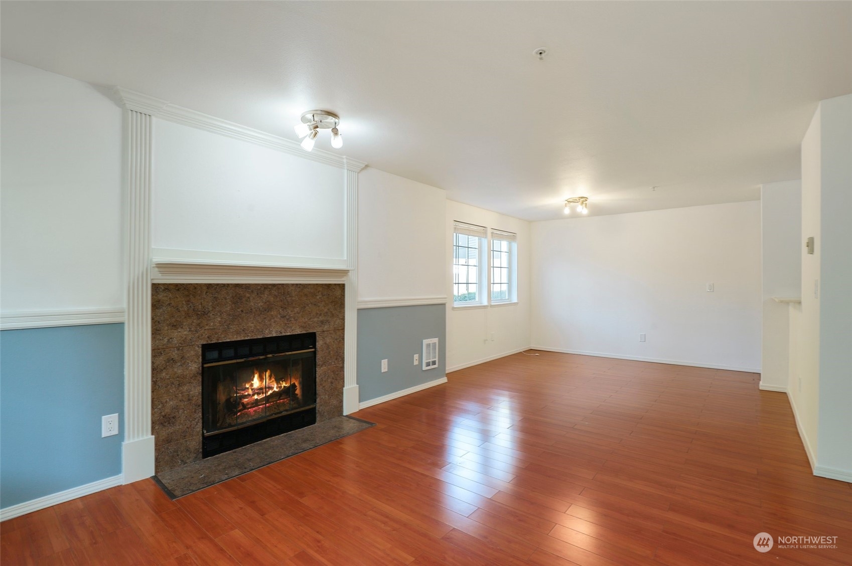 901 Sunset Boulevard Northeast, Unit D115 Renton, WA 98056 - Photo 5 of 19 a view of empty room with wooden floor fireplace and a window