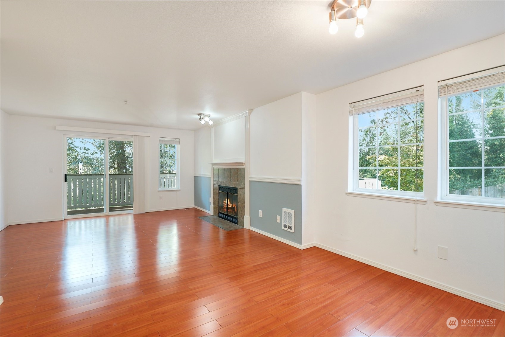 901 Sunset Boulevard Northeast, Unit D115 Renton, WA 98056 - Photo 6 of 19 a view of empty room with wooden floor and fireplace
