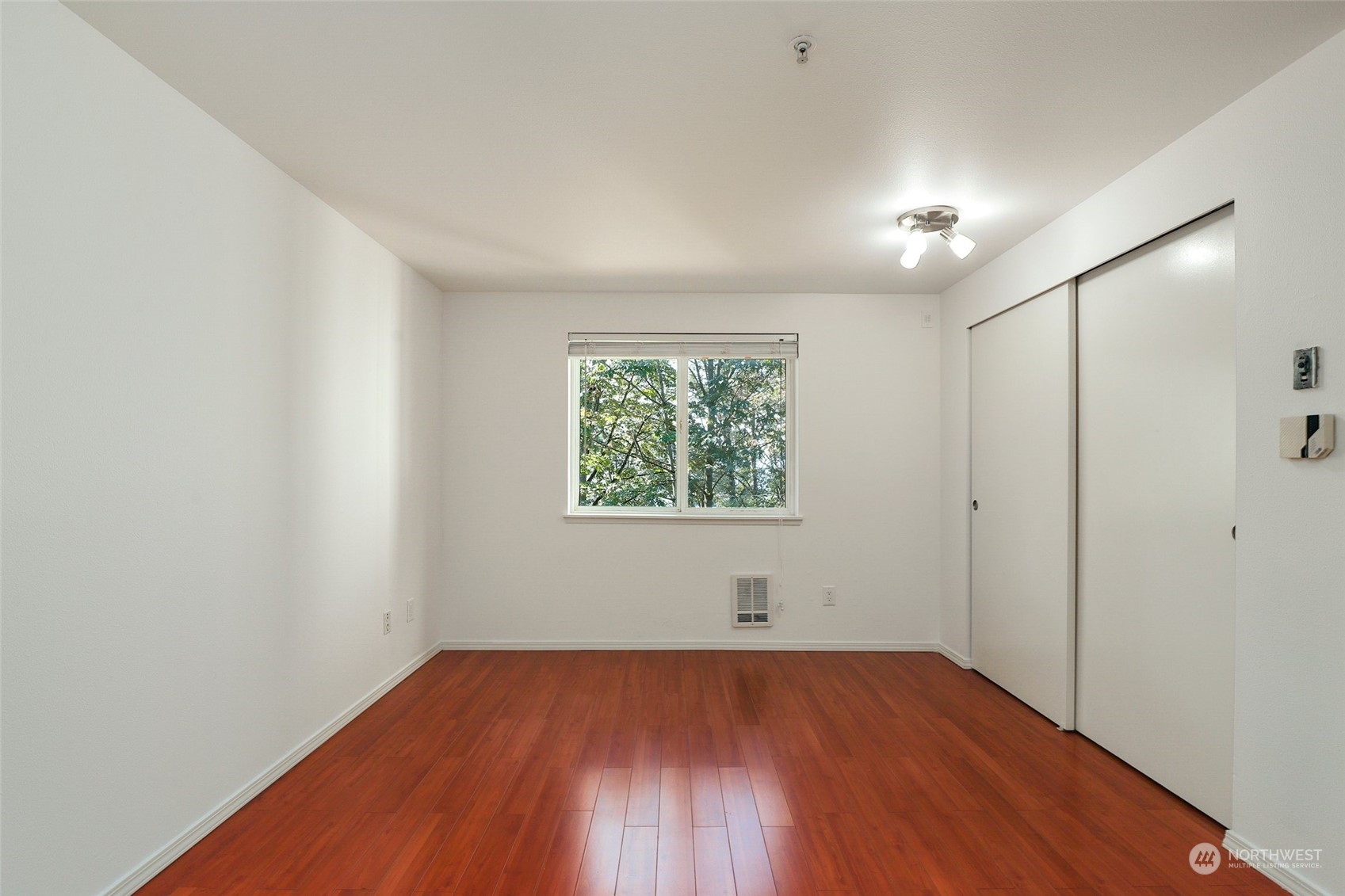 901 Sunset Boulevard Northeast, Unit D115 Renton, WA 98056 - Photo 9 of 19 an empty room with wooden floor and windows