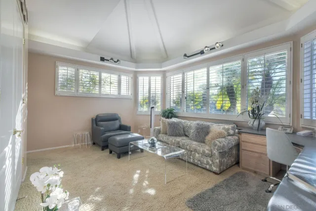 a living room with furniture and floor to ceiling windows