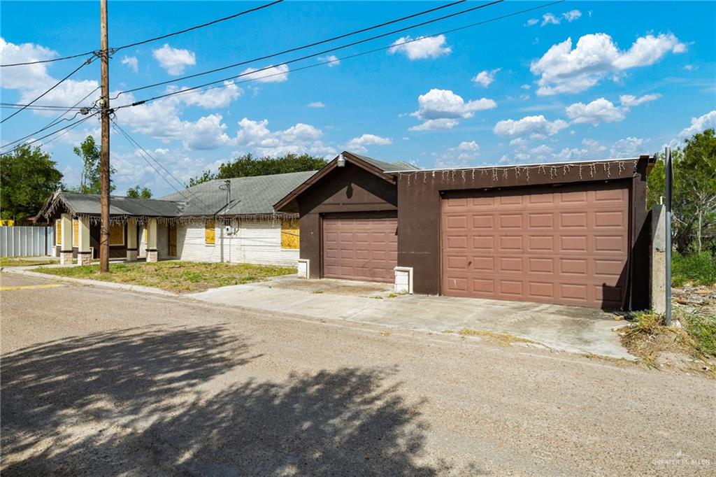 879 Austin Road Roma, TX 78584 - Photo 2 of 7 Exterior featuring a multi-car garage, covered entry porch with columns, and a shingle roof