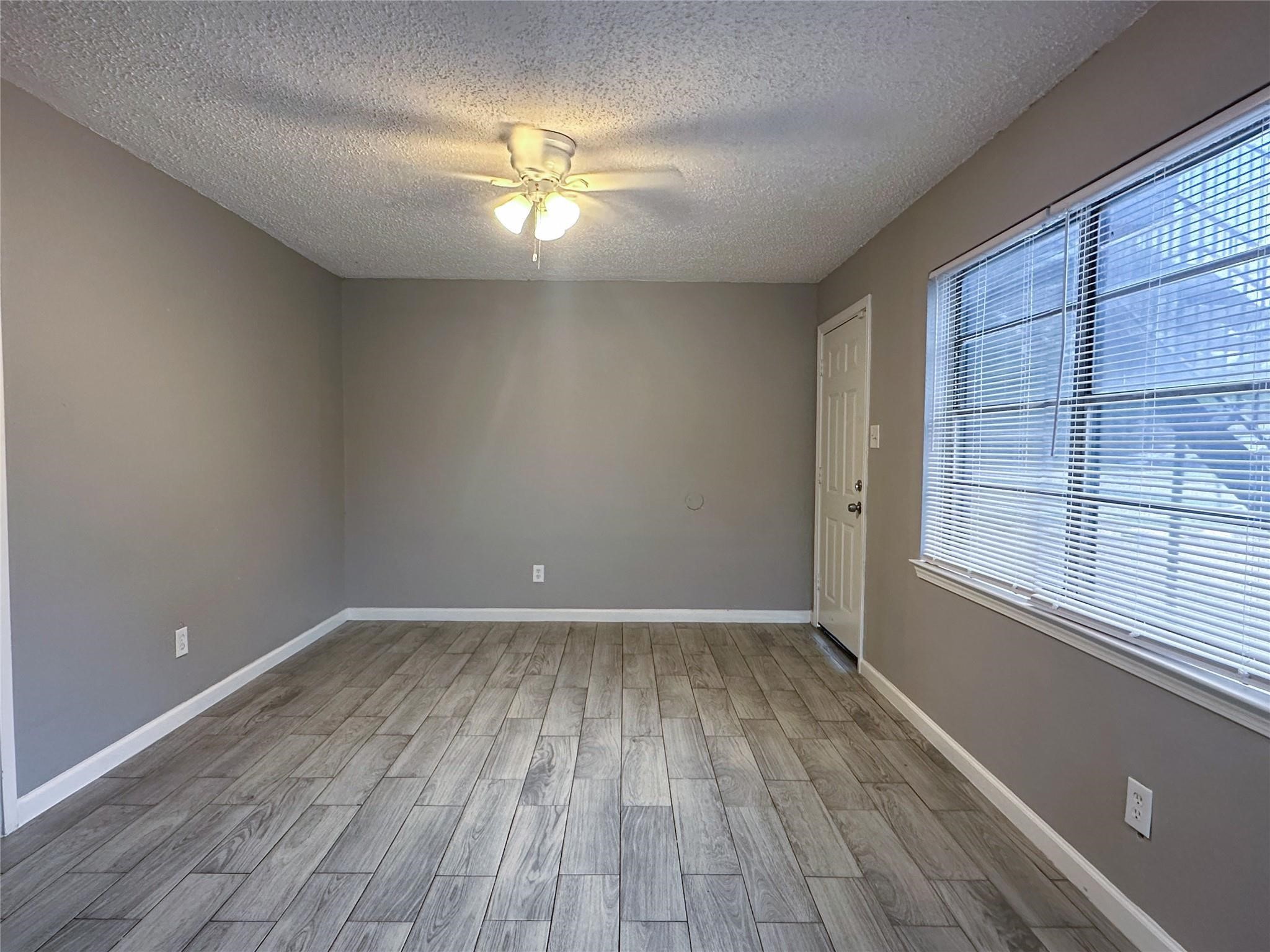 5418 Weaver Road, Unit A Houston, TX 77016 - Photo 2 of 11 wooden floor in an empty room with a window